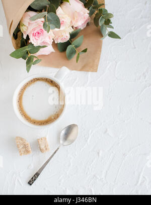 Romantische weibliche Hintergrund mit Kaffee und Rosen auf weiße strukturierte Tabletop, elegante leichte flatlay Stockfoto