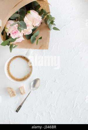 Romantische weibliche Hintergrund mit Kaffee und Rosen auf weiße strukturierte Tabletop, elegante leichte flatlay Stockfoto