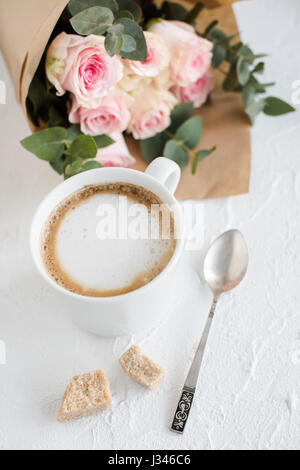 Romantische weibliche Hintergrund mit Kaffee und Rosen auf weiße strukturierte Tabletop, elegante leichte flatlay Stockfoto