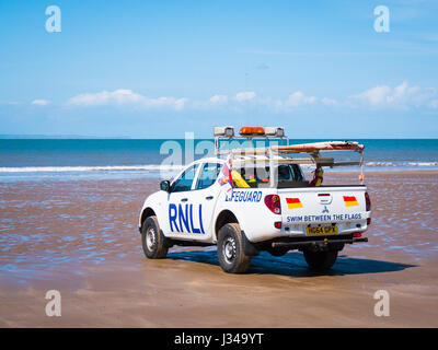 RNLI Rettungsschwimmer Pick-up LKW geparkt auf Croyde Strand in der Nähe der Brandung an einem sonnigen Tag mit blauem Himmel, Devon, England, UK Stockfoto