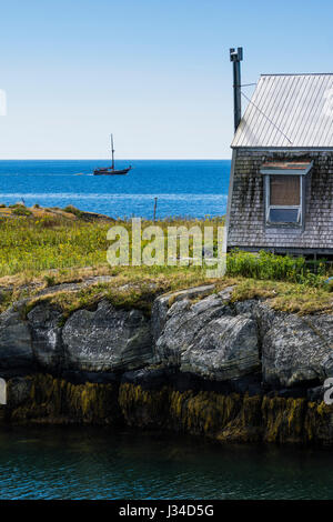 Ein Segelboot sitzt hinter einer kleinen Fisch-Hütte auf einer Insel im Hafen von Blue Rocks, Nova Scotia, Kanada. Stockfoto