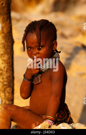 Junger Himba-Mädchen mit traditionellen Frisur in der Nähe von Epupa Wasserfälle. Himbas leben in der Kunene Region im Norden Namibias in der Grenze zu Angola, Namibia Stockfoto