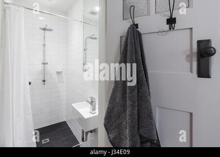 Kleine weiße geflieste Badezimmer mit Dusche und hängenden Handtuch auf einer horizontalen Haken Stockfoto