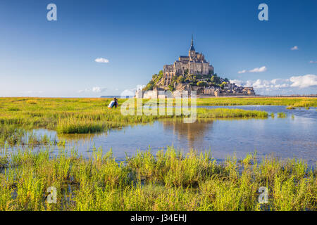 Klassische Ansicht der berühmten historischen Le Mont Saint-Michel-Gezeiten-Insel an einem sonnigen Tag mit blauem Himmel und Wolken im Sommer, Normandie, Nordfrankreich Stockfoto