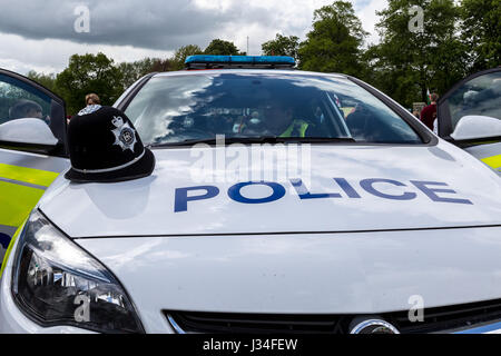 Weitwinkel erschossen von der Front und Motorhaube einer Polizei Streifenwagen mit Bedfordshire Polizei Helm sitzt auf der Motorhaube durch die Fahrertür markiert Stockfoto