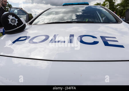 Weitwinkel erschossen von der Front und Motorhaube einer Polizei Streifenwagen mit Bedfordshire Polizei Helm sitzt auf der Motorhaube durch die Fahrertür markiert Stockfoto