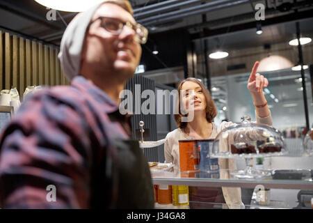 glückliche Frau, die etwas zu Barkeeper im café Stockfoto