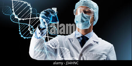 Wissenschaftler in Maske hält Kolben mit chemischen Stockfoto