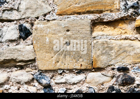 Mittelalterliche oder mittelalterliche Mass Dial zerkratzt in das Mauerwerk des südlichen Kirchenschiffs der St. James' Kirche, Cooling in Kent. Stockfoto