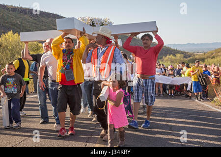 Tucson, Arizona - Teilnehmer in einem jährlichen Karfreitags-Prozession tragen ein großes Kreuz Sentinel Berg hinauf. Die Prozession hält für Stationen von der Stockfoto