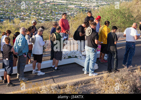 Tucson, Arizona - Teilnehmer in einem jährlichen Karfreitags-Prozession tragen ein großes Kreuz Sentinel Berg hinauf. Die Prozession hält für Stationen von der Stockfoto