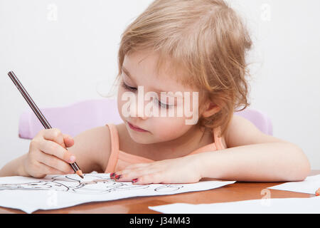 Kleines Mädchen zeichnen mit Farbstiften auf Papier Stockfoto