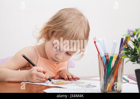 Kleines Mädchen zeichnen mit Farbstiften auf Papier Stockfoto