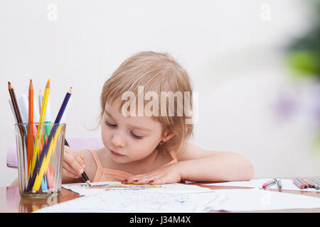 Kleines Mädchen zeichnen mit Farbstiften auf Papier Stockfoto