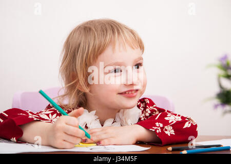 Kleines Mädchen zeichnen mit Farbstiften auf Papier Stockfoto