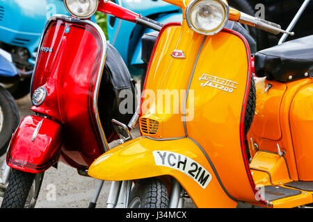 Orange Lambretta und rote Vespa Roller geparkt zusammen, Stockfoto