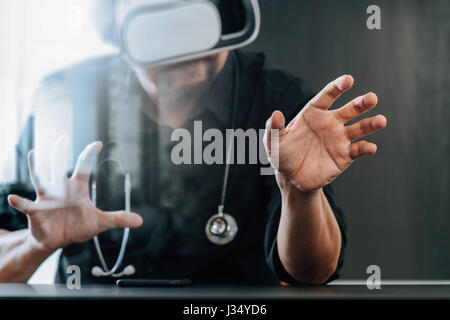 intelligente Arzt tragen virtual-Reality Brille in modernen Büros mit Mobiltelefon mit VR Kopfhörer Stockfoto
