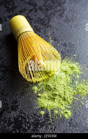 Grünen Matcha Teepulver und Bambus-Pulver auf schwarzen Tisch. Stockfoto