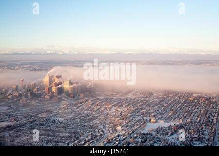 Eine Vielzahl von Emissionen von Gebäuden in der Innenstadt und Luftverschmutzung über Calgary bei kaltem Wetter Stockfoto