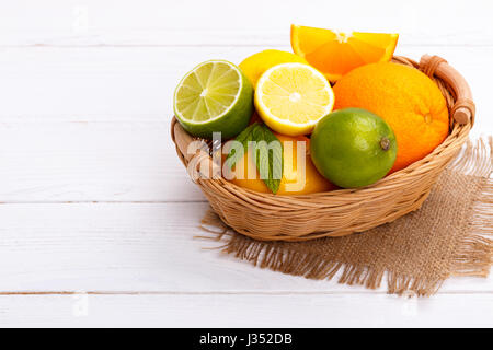 Korb von Zitrusfrüchten auf weißem Holz Hintergrund Stockfoto