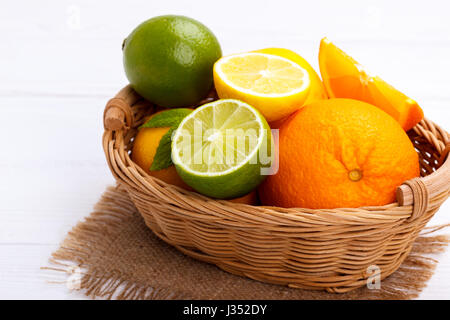 Korb von Zitrusfrüchten auf weißem Holz Hintergrund Stockfoto