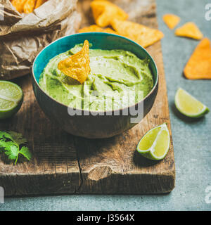In blaue Schale und Chips, quadratische Ernte frische Guacamole sauce Stockfoto