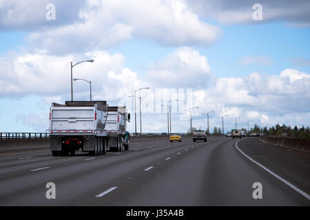 Professionelle Sattelschlepper mit zwei selbst entladen Anhänger für Schüttgut für Landschaftsbau oder Baustoffe auf der interstate Straße. Stockfoto