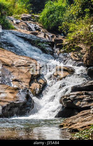 Wasserfall im tropischen Urwald in Thailand, scharfe grüne gelbe Wasser Stockfoto