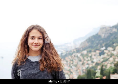 Junges Mädchen in Roquebrune mit Monte-Carlo-Küste im Hintergrund Stockfoto