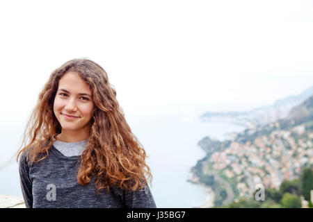 Junges Mädchen in Roquebrune mit Monte-Carlo-Küste im Hintergrund Stockfoto