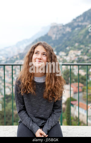 Junges Mädchen in Roquebrune mit Monte-Carlo-Küste im Hintergrund Stockfoto