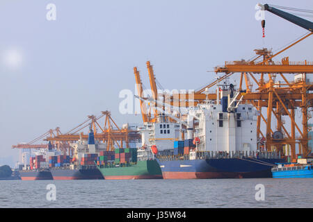 kommerzielle Containerschiff auf Port nutzen für den Wassertransport und Schiff Hof Kran verladen Güter Stockfoto