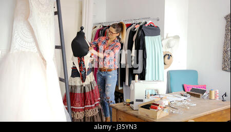 Junge weibliche Schneider arbeiten im Salon und Dressing Schaufensterpuppe in Freizeitkleidung. Stockfoto