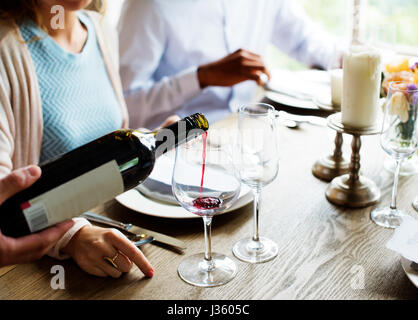 Poring Kellner servieren Rotwein zu Kunden in einem Restaurant Stockfoto