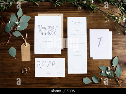 Hochzeit Einladung Karten Papiere Handauflegen Tisch dekorieren mit Blättern Stockfoto