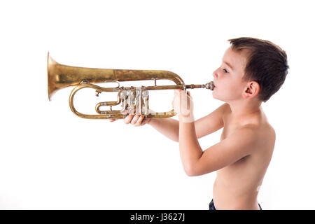 kleiner Junge bläst in eine Trompete vor weißem Hintergrund Stockfoto