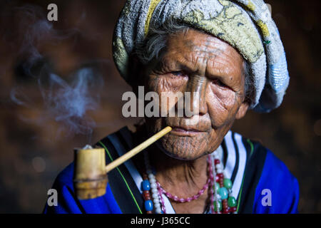 Kinnbereich, Myanmar, 11. November 2014: Muun Stamm Kinn Dame in ihrer Küche, ihre Pfeife rauchen Stockfoto