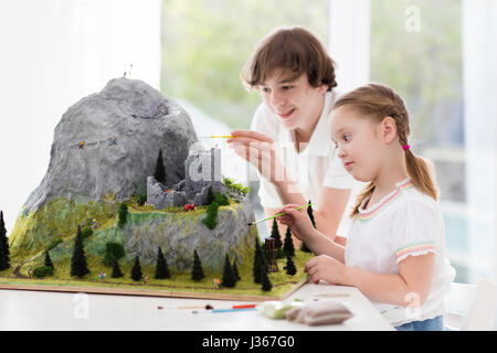 Kinder arbeiten an Modellbau Schulprojekt. Kinder bauen Miniatur Maßstab Modell Mountain für Erdkundeunterricht. Außerschulische Aktivitäten und Hobby-cl Stockfoto