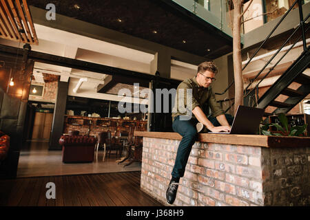 Schuss von kreativen professionelles Arbeiten am Laptop. Junger Mann im Büro Café mit Laptop-Computer. Stockfoto