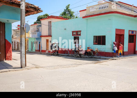 Lokale Leben auf der Straße in Trinidad, Sancti Spiritus, Kuba. Typische Szene aus ländlichen Kuba mit Pastell farbigen Gebäuden, Oldtimer und Motorräder. Stockfoto