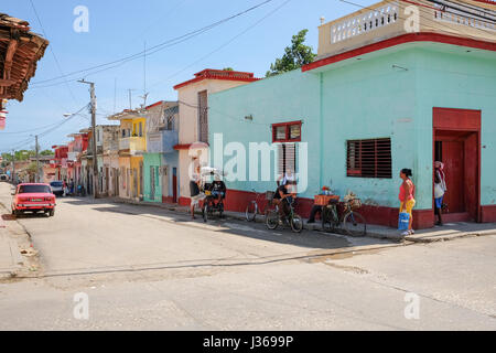 Lokale Leben auf der Straße in Trinidad, Sancti Spiritus, Kuba. Typische Szene aus ländlichen Kuba mit Pastell farbigen Gebäuden, Oldtimer und Motorräder. Stockfoto