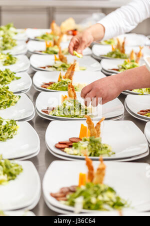 Köche bereiten leckere Vorspeise Speisen an Bord Restaurant Küche Stockfoto