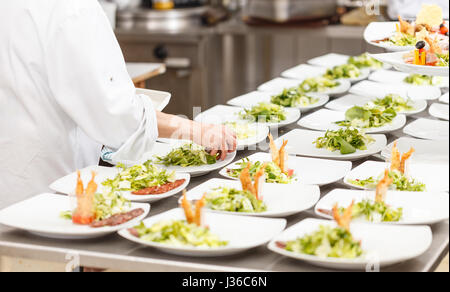 Köche bereiten leckere Vorspeise Speisen an Bord Restaurant Küche Stockfoto