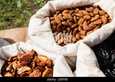 Getrocknete Pflaumen, Äpfel und Mandeln Nüssen in kleine weiße Leinen Säcke auf dem Display zum Verkauf an lokale Lebensmittel-Messe. Niemand um ihn herum. Stockfoto