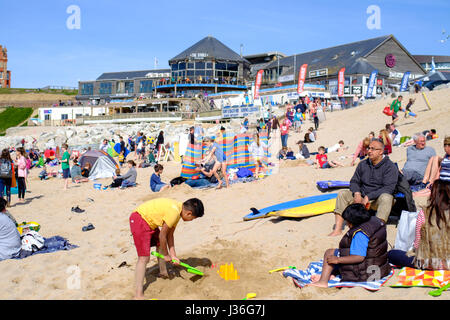 Newquay, Großbritannien. Strandurlauber geniessen Sie die Sonne auf einer hellen und sonnigen Frühling Nachmittag auf den Fistral Beach in Newquay. Stockfoto