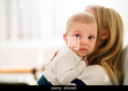 Schöne junge Mutter Baby Sohn in den Armen zu halten Stockfoto