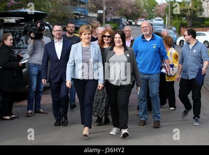 Erste Minister und SNP Führer Nicola Sturgeon mit SNP Glasgow Group Leader Susan Aitken (Mitte rechts) wie sie in Toryglen, Glasgow, vor Kommunalwahlen am Donnerstag zu werben. Stockfoto