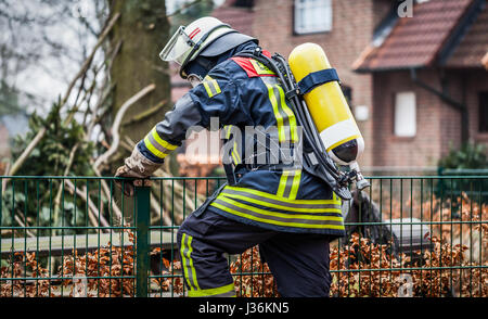 Feuerwehrmann im Einsatz im Freien mit Sauerstoffmaske und Sauerstoffflasche Stockfoto