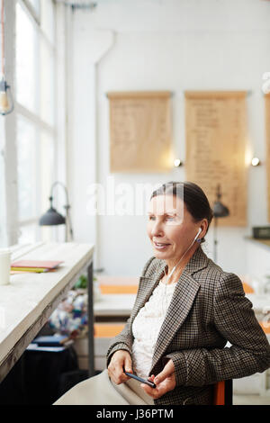 Nachdenklich Reife Frau im Panorama-Fenster Stockfoto