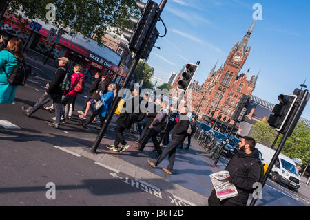 Menschen Sie Kreuzung Euston Road nach Beenden von Kings Cross Station in Morgen, London, England, Großbritannien Stockfoto